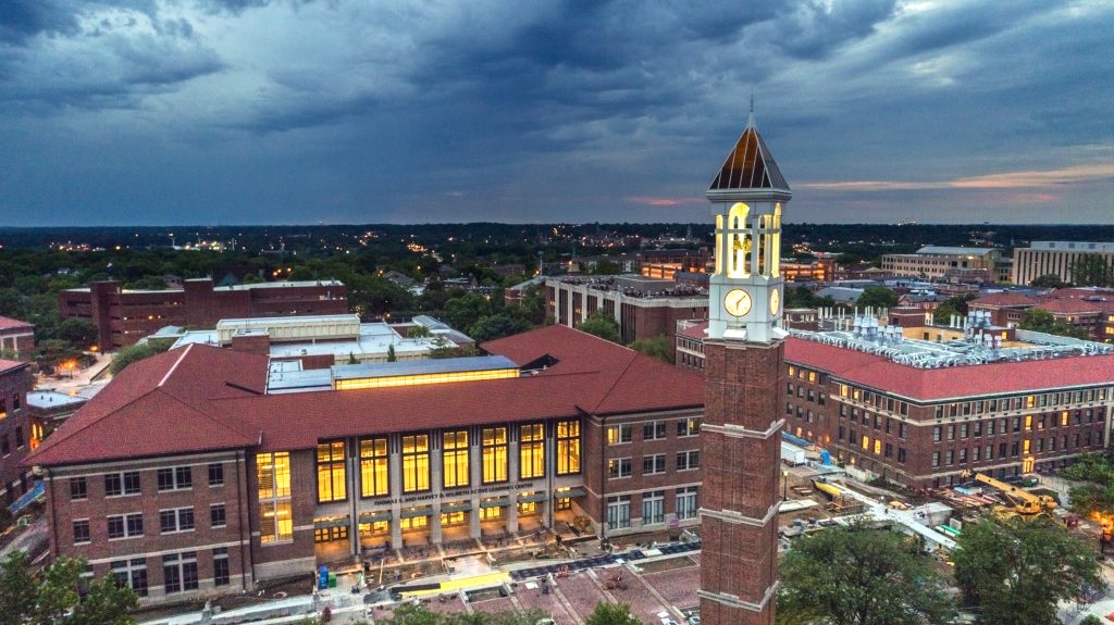 An aerial view of Purdue University's Bell Tower on a cloudy evening with the rest of campus stretched out behind it.